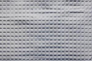 Closeup full-frame background and texture of aluminum coated butil rubber sheet with square pattern. photo