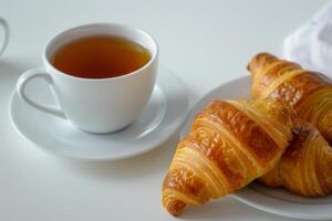 French Croissant and Tea Delight Isolated on White Background photo