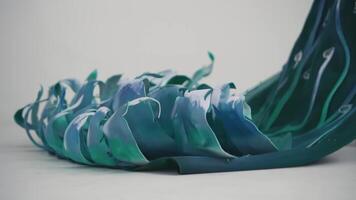 Abstract swirls of blue and green paint creating a wave-like pattern on a white background. video