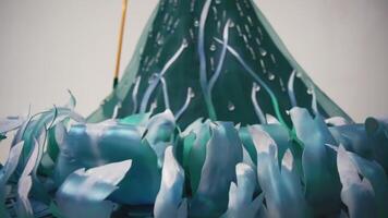 Abstract close-up of a green and blue textured fabric with a flowing, wavy pattern and water droplets. video