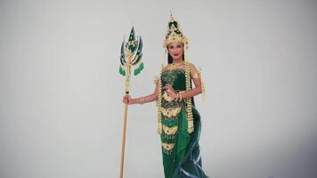 Traditional Thai dancer in ornate costume performing with a decorative spear against a white background. video