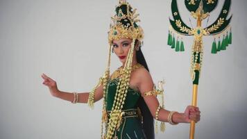 Woman in traditional Balinese dance costume with ornate headdress and green attire. video