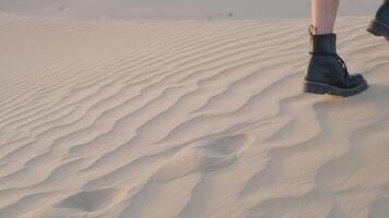 un' ragazza con un' skateboard passeggiate lungo il sabbia dune nel il deserto video