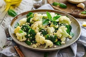 Fresh broccoli and cauliflower salad with Tahini dressing on plate photo