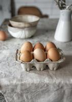 Freshly laid brown eggs rest on a linen covered kitchen counter photo