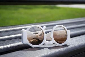 White sunglasses on a bench close up. photo