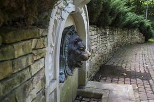 Old stone fountain with lion statue. photo