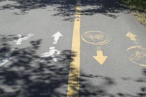 Road sign on asphalt with shadows of tree. photo