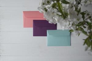 Bright envelopes on a white wooden table photo