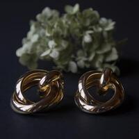 Golden earrings on a black background with decor photo