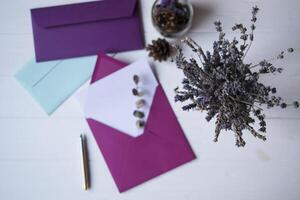 The pink envelope with note blank on the white wooden table. Beautiful desktop. Background with place for text. photo