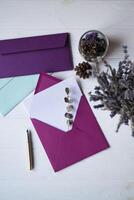 The pink envelope with note blank on the white wooden table. Beautiful desktop. Background with place for text. photo