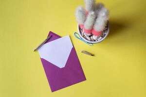 The envelope with note blank on the yellow background near cactus. Background with copy space. photo