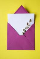 The pink envelope with note blank on the yellow background. Background with copy space. photo