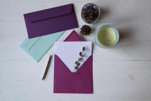 The pink envelope with note blank on the white wooden table. Beautiful desktop. Background with place for text. photo