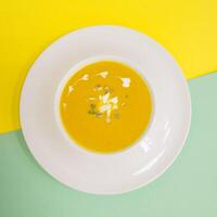 Pumpkin cream soup on bright background. photo