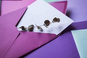 The pink envelope with note blank on the white wooden table. Beautiful desktop. Background with place for text. photo