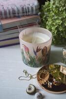 Put out candle with smoke. Home decor and female accessories on a table, close up. photo