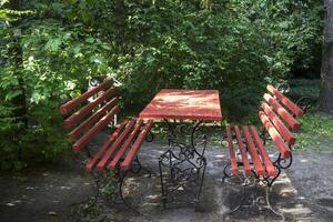 rojo banco y mesa en el parque. foto