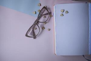 Eye glasses and opened notebook on a table. photo