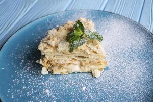 The napoleon cake in a plate on a table. photo