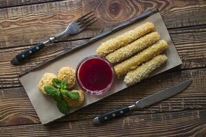 The cheese sticks with sauce, on a wooden table. photo