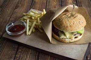 Burger and french fries on a wooden table. photo