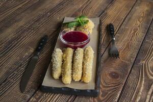 The cheese sticks with sauce, on a wooden table. photo