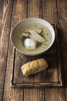 Chicken soup in a bowl on a wooden table. photo