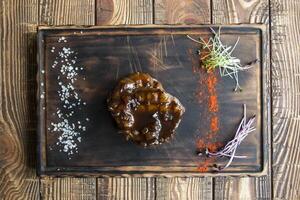 Grilled meat with spices and sauce on a wooden table. photo