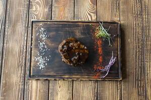 Grilled meat with spices and sauce on a wooden table. photo