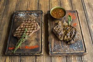 Grilled meat with spices and sauce on a wooden table. photo