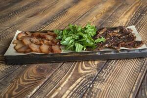 A meat plate on a wooden background. photo