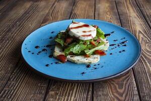 The salad with cheese on a wooden table. photo