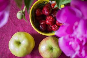 Apples and srawberry on the kitchen table. photo