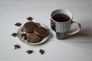 un taza de café con chocolate galletas, en un blanco de madera mesa. foto