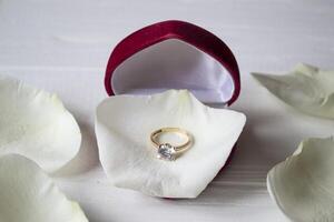 Golden ring on white petals of roses. photo