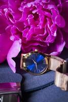 Female wrist watch and peony, close up. photo