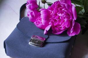 Pink peony and female bag close up. photo