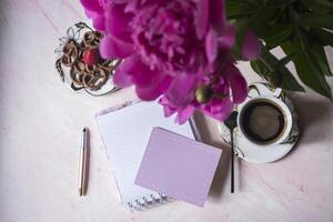 Coffee, empty paper and peony. Background with place for text. photo