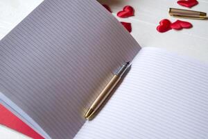 rojo velas, amor corazones y cuaderno en el mesa. hermosa fondo con Copiar espacio. foto