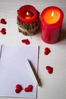 Red candles, love hearts and notebook on the table. Beautiful bckground with copy space. photo