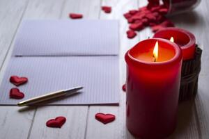 Red candles, love hearts and notebook on the table. Beautiful bckground with copy space. photo