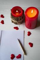 Red candles, love hearts and notebook on the table. Beautiful bckground with copy space. photo