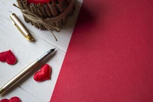 Red notebook, candle and love hearts on a desk. photo