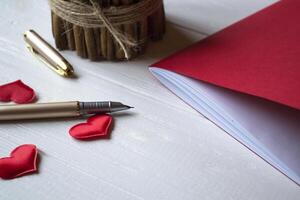 Red notebook, candle and love hearts on a desk. photo