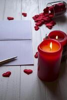 Red candles, love hearts and notebook on the table. Beautiful bckground with copy space. photo