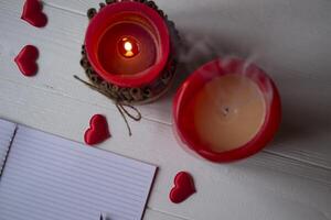 Red candles, love hearts and notebook on the table. Beautiful bckground with copy space. photo