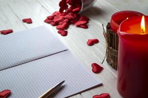 Red candles, love hearts and notebook on the table. Beautiful bckground with copy space. photo