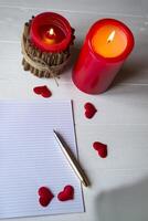 Red candles, love hearts and notebook on the table. Beautiful bckground with copy space. photo